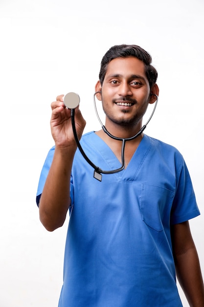 Young indian male Doctor holding stethoscope in hand on white background.