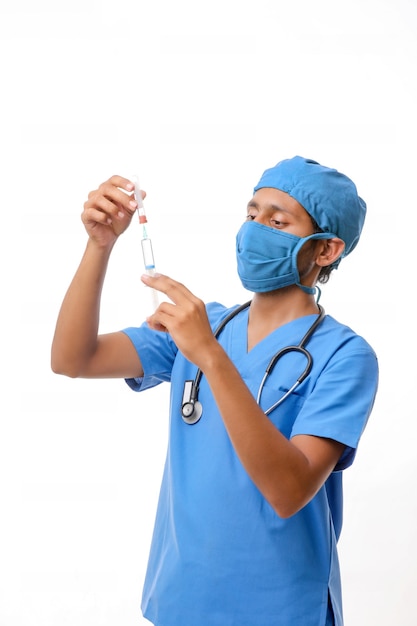 Young indian male Doctor loading syringe on white background.