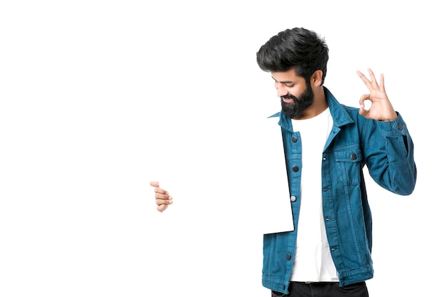 Young Indian male showing blank signboard on white background