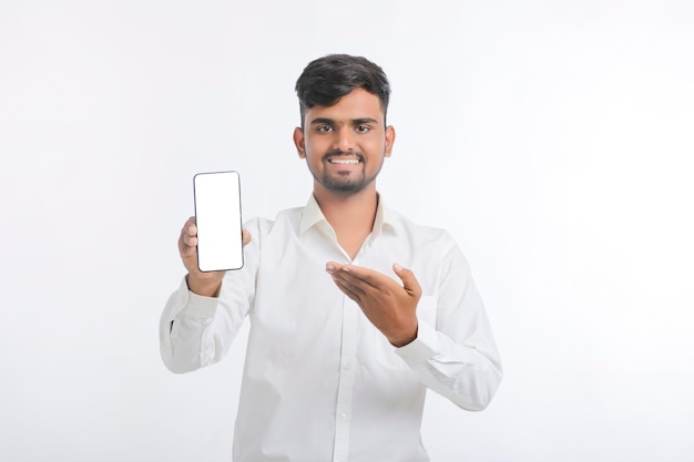 Young indian male showing smartphone Screen on white background.