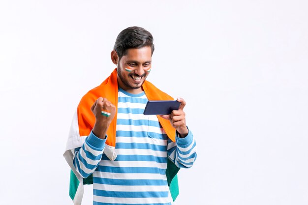 Young indian man celebrating independence day or republic day and using smartphone