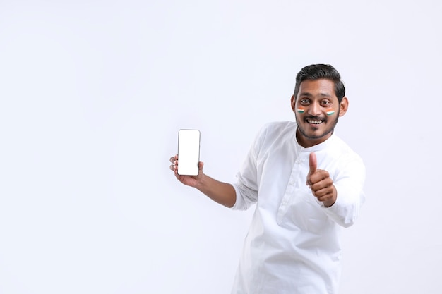 Young indian man celebrating independence day and showing smartphone.