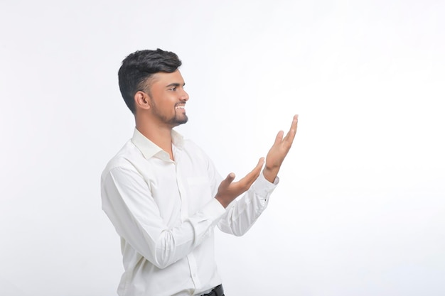 Young indian man giving expression with hand over white background.