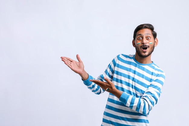 Young indian man giving shocking expression and showing direction with hand