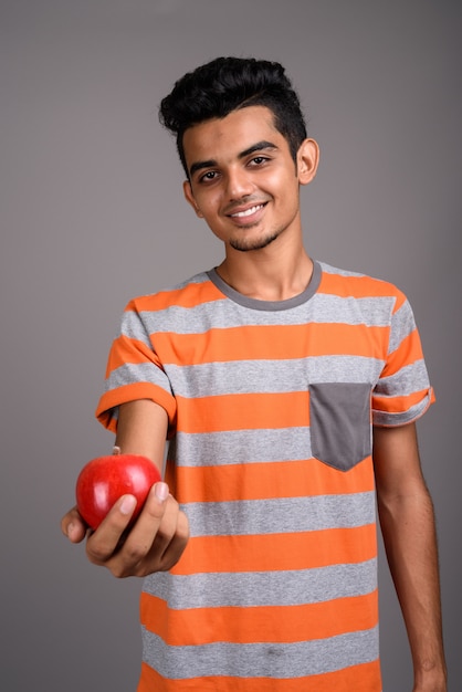 Young Indian man on gray wall