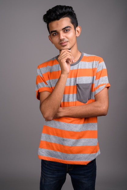 Young Indian man on gray wall