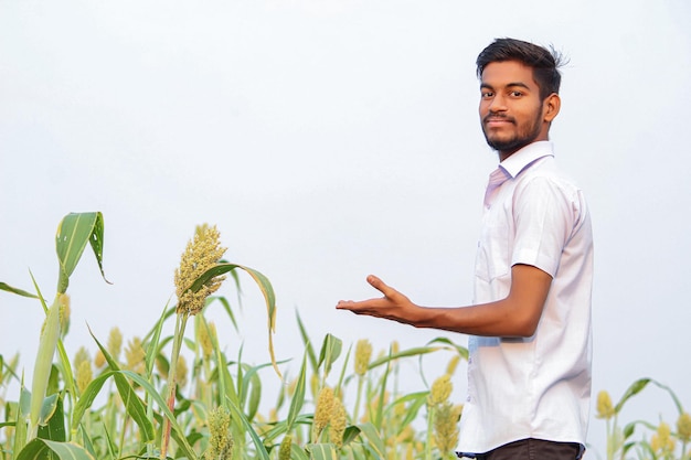 Молодой индийский мужчина на зеленом поле сельского хозяйства