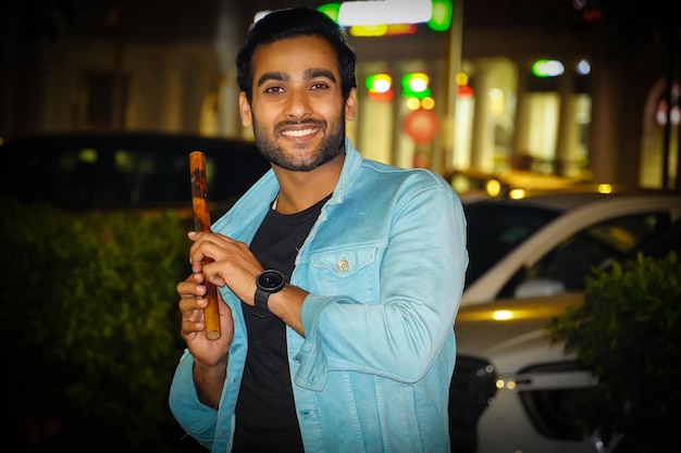 A young Indian man having bansuri Indian flute and giving smile