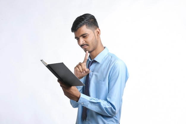 Young indian man holding diary in hand and thinking some idea