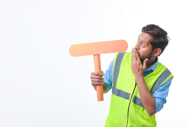 Young indian man holding a empty sign board on white background. construction work concept