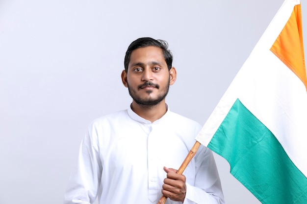 Young indian man holding indian national flag in hand over white background