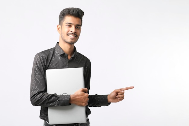 Young indian man holding laptop in hand on white background.