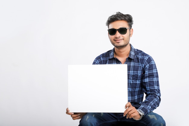 young indian man holding poster