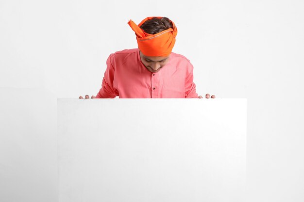 Photo young indian man holding white card board on white wall