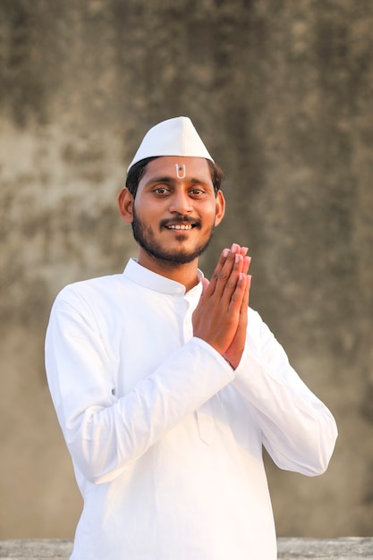 Young indian man (pilgrim) giving Namaste or welcome gesture.