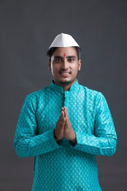 Photo young indian man (pilgrim) in traditional wear and giving namaste or welcome gesture.