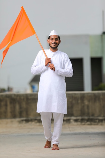 전통 의상을 입고 종교 깃발을 흔드는 젊은 인도 남자(순례자).