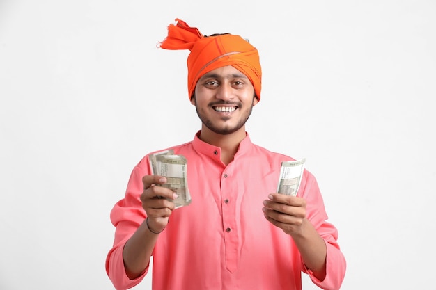 Young Indian man posing with currency on white wall