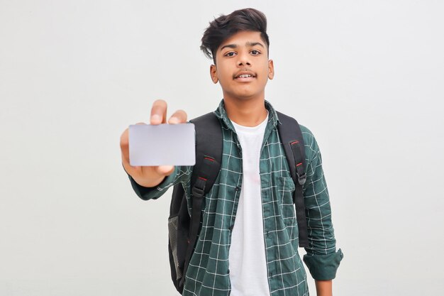 Young indian man showing debit or credit card on white background.