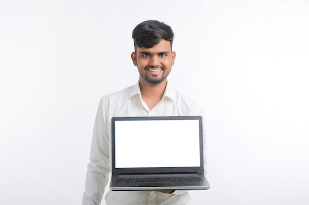 Young indian man showing laptop screen with copy space on white background.