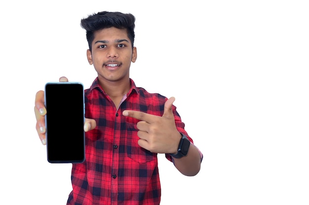 Young indian man showing smartphone screen on white background.