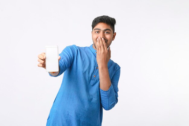 Young indian man showing smartphone screen on white background.