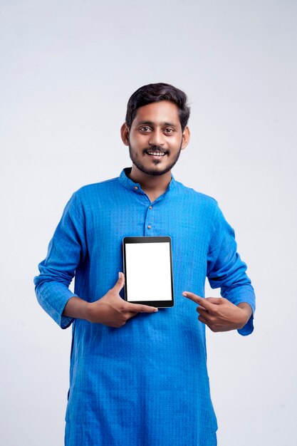 Young indian man showing tablet over white background.