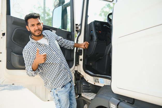 Foto giovane indiano in piedi vicino al suo camion il concetto di trasporto merci