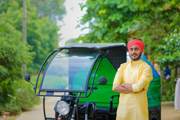 Young indian man standing with garbage van