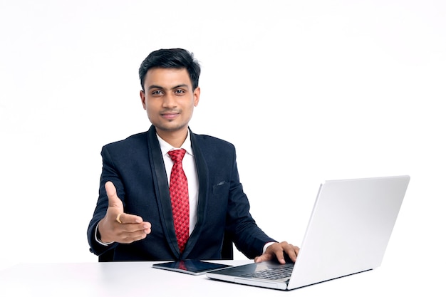 Young indian man in suit and working on laptop at office