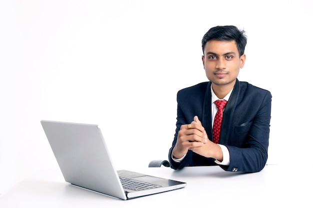 Young indian man in suit and working on laptop at office