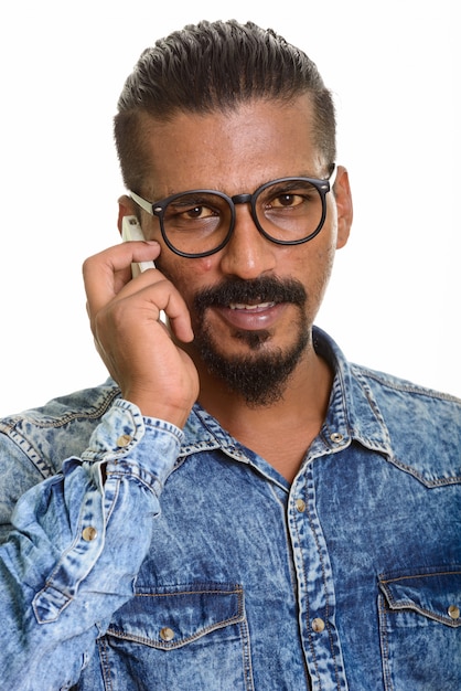 Young Indian man talking on mobile phone isolated