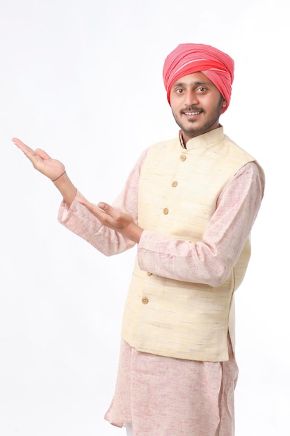 Young indian man in traditional wear and giving expression on white background.