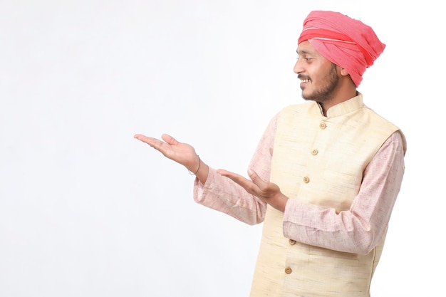 Young indian man in traditional wear and giving expression on white background.