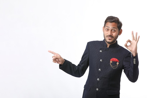 Young indian man in traditional wear and giving expression on white background.