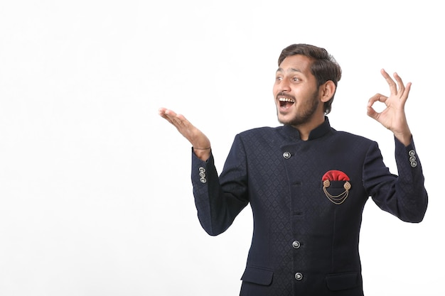 Young indian man in traditional wear and giving expression on white background.