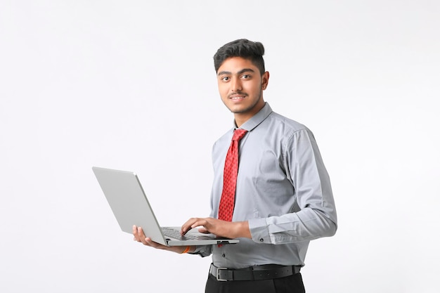 Young indian man using laptop on white background.