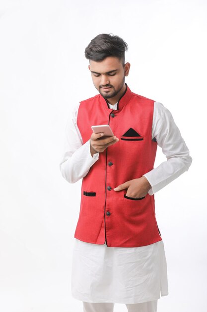 Young indian man using smartphone on white background.