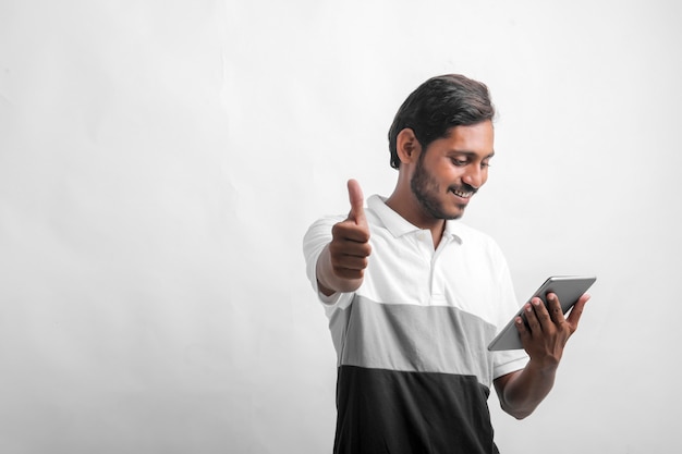 Young indian man using tablet over white background.