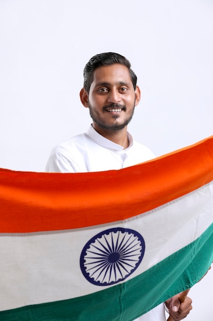 Young indian man waving indian national flag. celebrating independence day