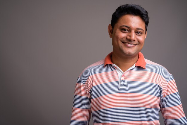 young Indian man wearing long sleeve striped polo shirt 