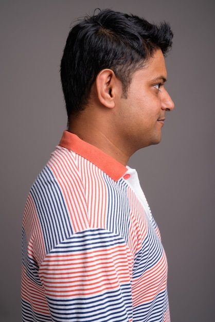 young Indian man wearing long sleeve striped polo shirt 