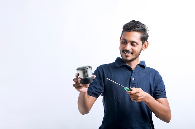 Young indian man who repair electronics kitchenware holding tools in hand