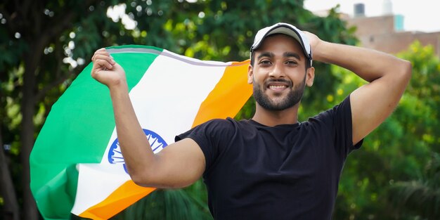 Молодой индийский мужчина с индийским флагом