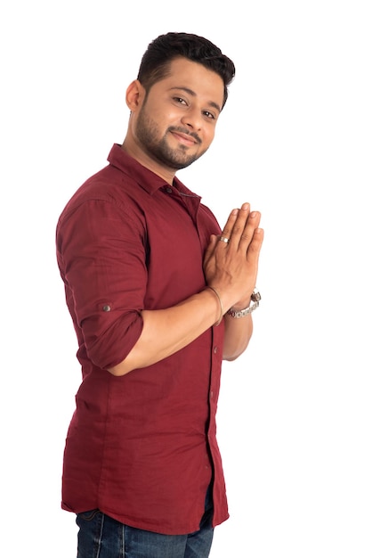 Young Indian man with welcome expression or inviting or greeting Namaste on a white background