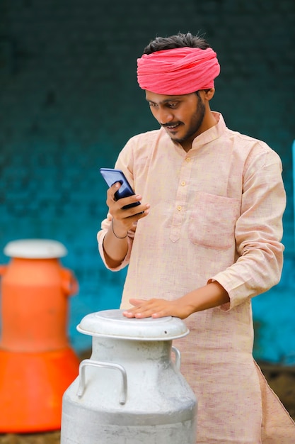 Молодой индийский молочник с помощью смартфона