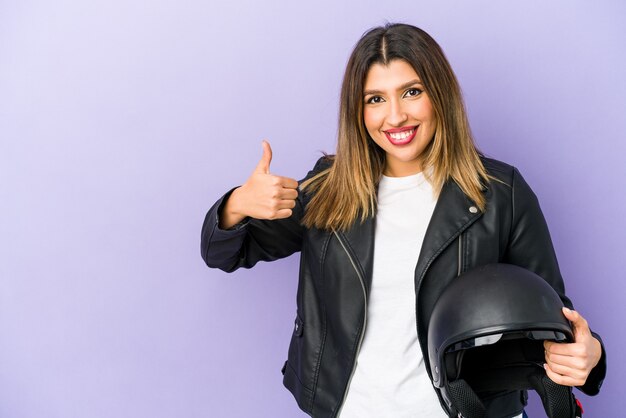 Young indian motorbiker woman isolated smiling and raising thumb up