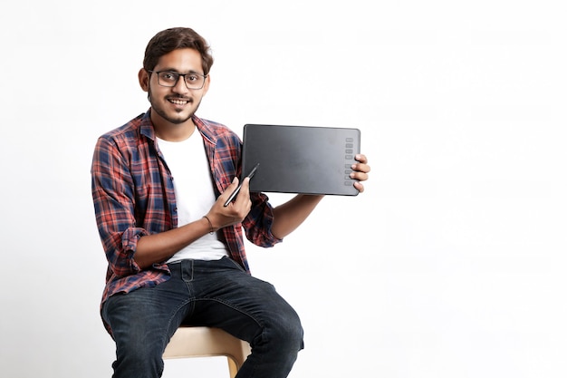 Young indian professional designer showing graphic tablet with digital pen