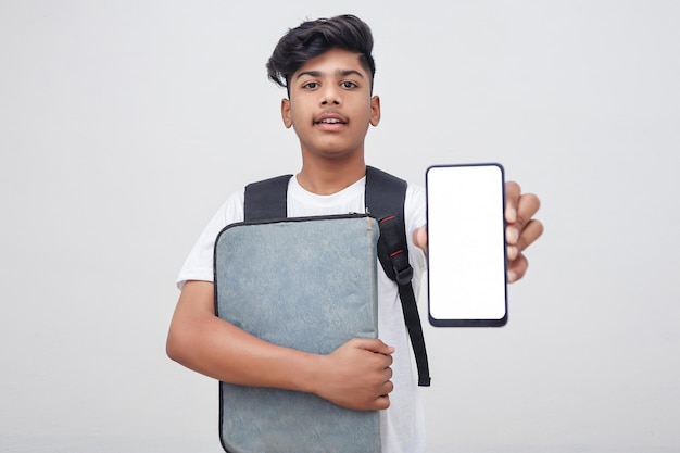 Young indian student holding file and showing smartphone screen on white background.