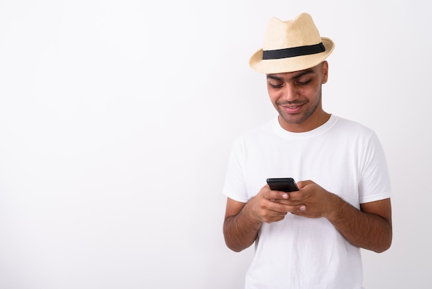 Young Indian tourist man wearing hat on white